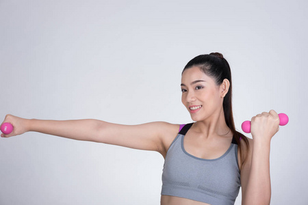亚洲体育少妇与哑铃训练。漂亮的运动员