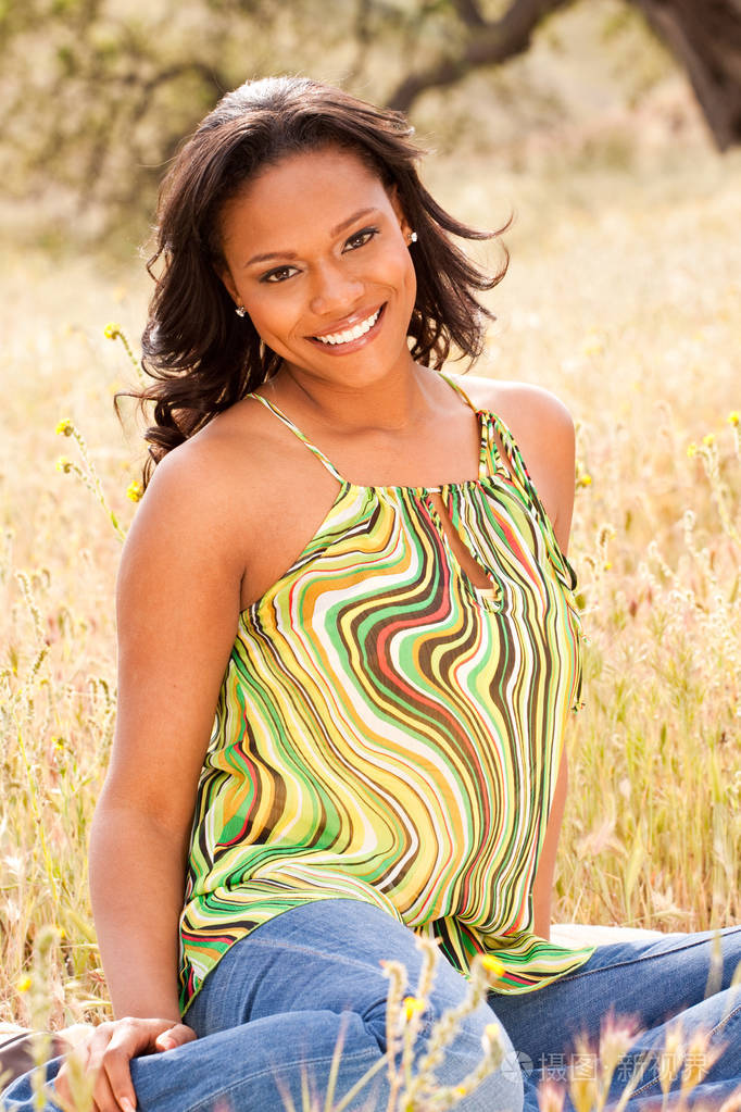 幸福的女人坐在外地微笑