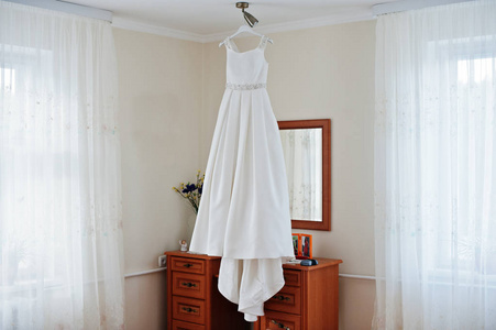 在房间的架子上挂着的婚纱图片