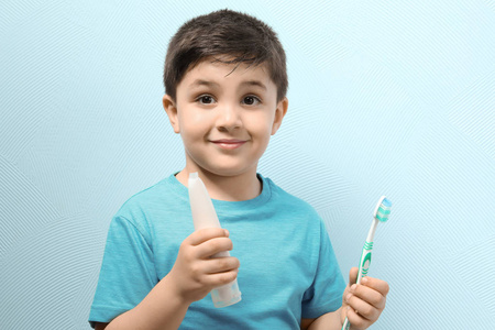 用牙刷和粘贴颜色背景的可爱男孩。牙齿清洁概念