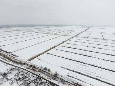 顶视图的犁过的田野，在冬天。一片麦田在雪中