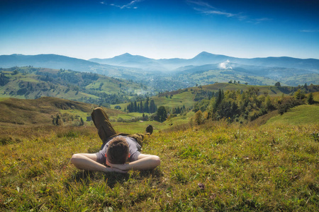 男子躺在草丛中的一座小山和享受谷