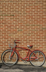 倚在墙上砖红色复古自行车