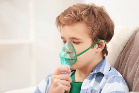 在家中使用雾化器治疗哮喘和呼吸道疾病的年轻男孩