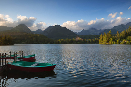 全景图山，越过 Tatra 山脉湖 Strbskepleso。夏季日落颜色和游泳的船上
