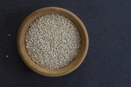Sesam 种子在碗木制自然光很少。选择性的焦点