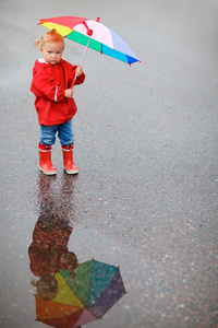 花伞雨天上蹒跚学步的女孩