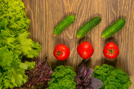 新鲜的蔬菜。西红柿和黄瓜木制的桌子上。厨房里的调味品