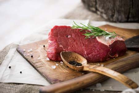 生牛肉整块洒上盐和胡椒和迷迭香树叶