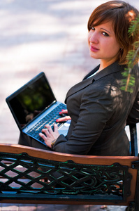 笔记本电脑在公园里的年轻女子