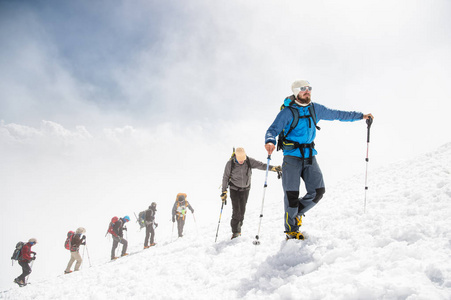 一群登山爬到白雪皑皑的山顶图片
