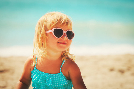 防晒防晒霜在海滩的小女孩