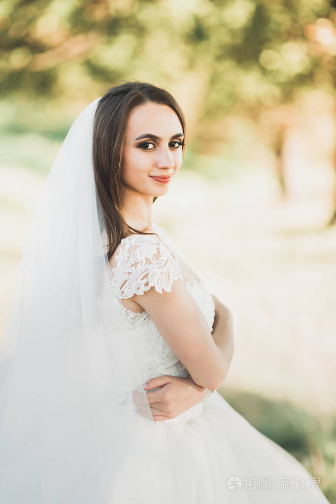 摆在户外穿着婚纱的美丽新娘