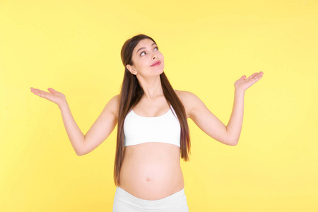 年轻孕妇选择婴儿在黄色背景上的名称