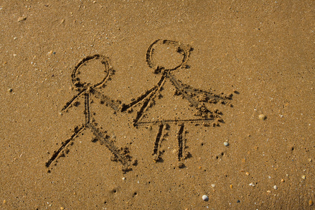 女孩和男孩画在沙滩上。