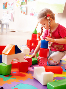 儿童与拼图块和建筑设置在游戏室。