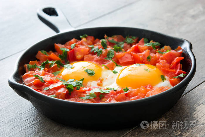 Shakshuka 在铁煎锅木制的桌子上。在以色列的典型食品