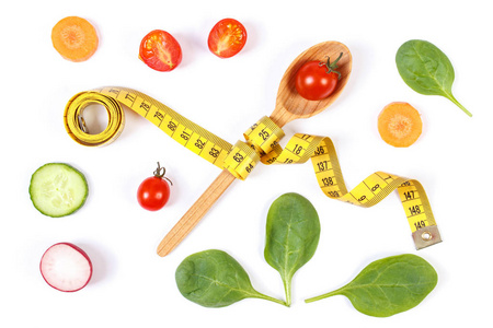 勺子与厘米和蔬菜，减肥和健康营养概念