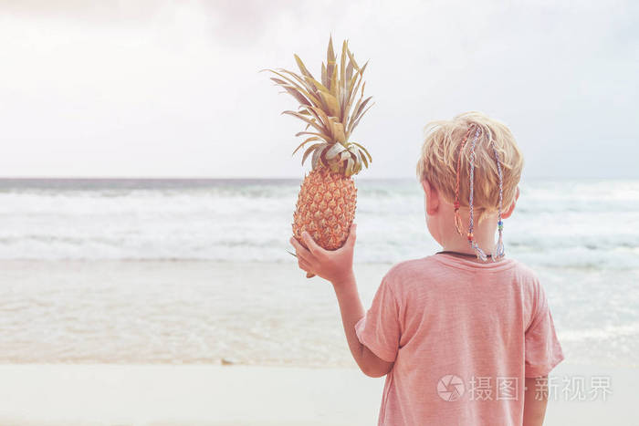 来自欧洲的白人男孩抱着菠萝与快乐和放松