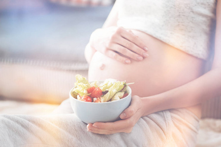 孕妇拿着蔬菜沙拉