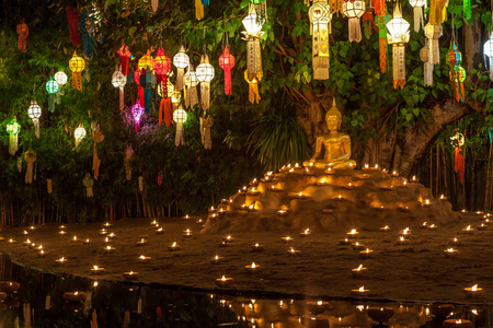 佛像周围有蜡烛和色彩缤纷的灯笼