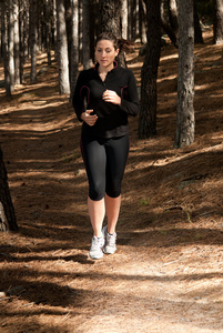 一位年轻女子在树林中奔跑，户外背景