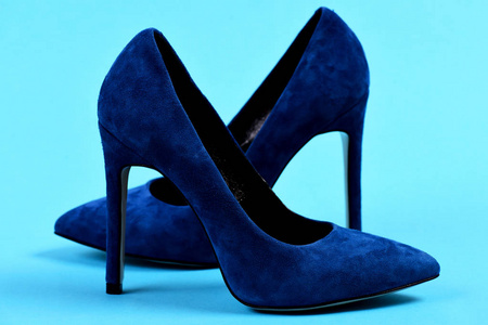 优雅的蓝鞋，在蓝色背景作为购物的概念