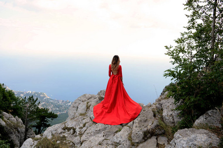 在山上的断崖边上长长的红衣服的女人。艾峰佩特里山