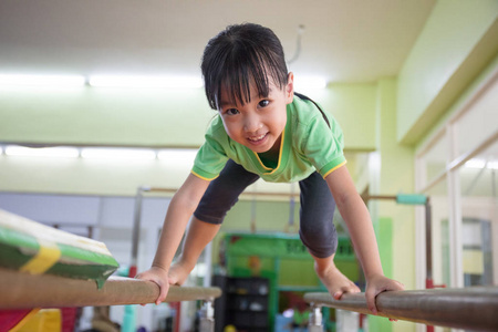 亚洲的中国小女孩爬上双杠图片