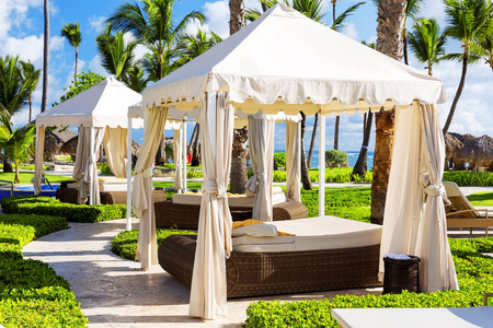 热带海滩度假酒店，带有遮阳伞和躺椅