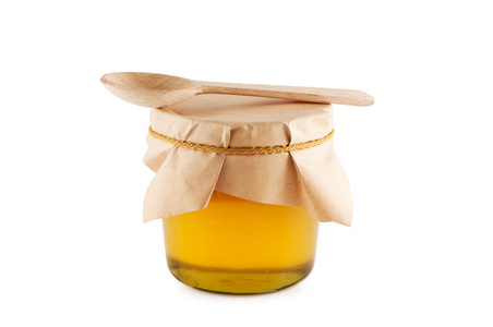 蜂蜜在罐子里的木制勺子隔离。