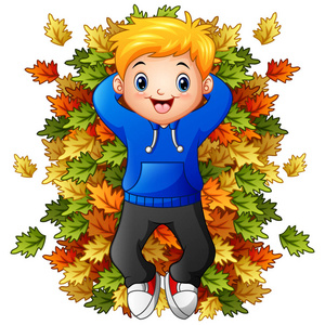 落叶男孩快乐的小男孩玩耍着秋天的落叶照片