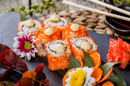 寿司卷Maki 寿司，生鱼片装饰着花朵。日本料理。选择性的焦点
