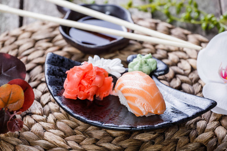 寿司套的饭和寿司卷用竹背景花朵装饰。日本料理。选择性的焦点