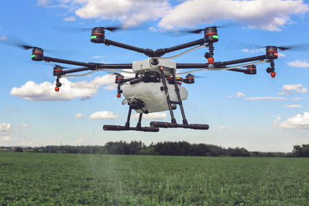 农业无人机飞到喷肥在绿色的田野上