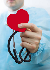 男性医学医生持有穿着红色的手玩具心和听诊器特写黑色背景。运用有氧运动，医生让心脏，心率物理量，心律失常概念