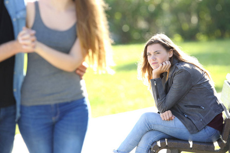 嫉妒的女孩,看着一对夫妇散步照片