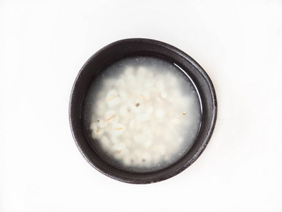 黑碗中的小米汤的顶部视图在厨房里被隔离的白色