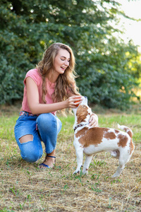 漂亮的女孩和一只小猎犬小狗一起玩