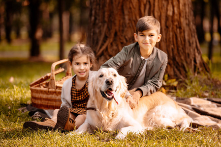 里小女孩与唐综合征抚摸拉布拉多猎犬头儿童在动物园愉快的家庭在厨房