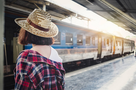 漂亮女人在等火车在火车站夏季旅行。旅游概念