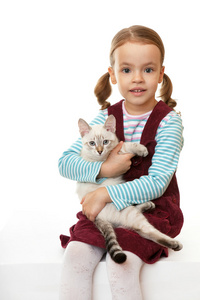 漂亮的小女孩带着一只小猫。