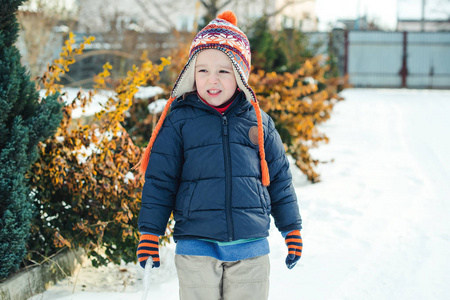 可爱的小男孩走在冬天的时候室外。孩子玩雪