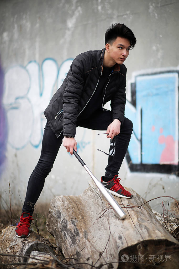 亚洲年轻男人在街上摆着摄像机