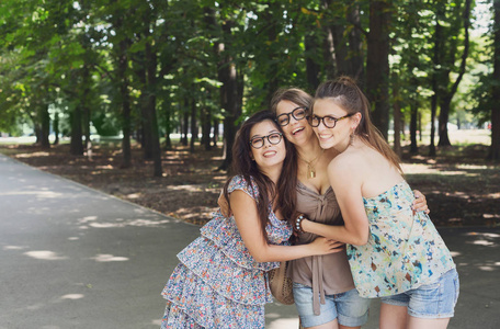 走在公园的三个美丽年轻的波西米亚风格别致时尚女孩