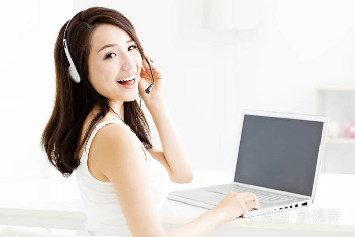 笔记本电脑与耳机年轻微笑美女