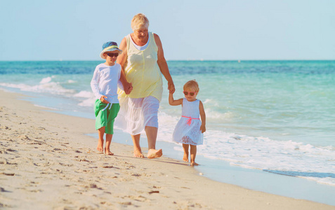 与孩子们在海滩上的快乐祖母