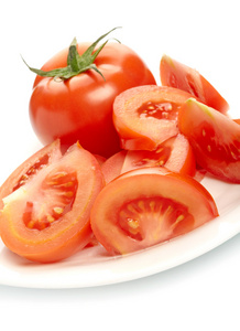 在白色背景下分离的盘子上的番茄和切片