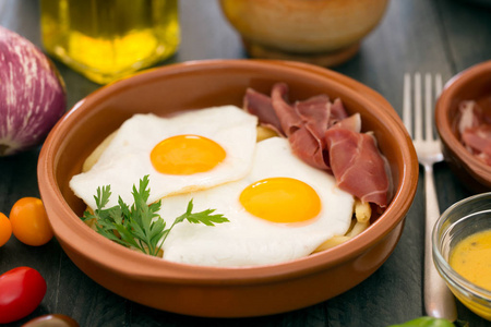 陶瓷杯与西班牙 jamon 黑色木制背景早餐煎蛋