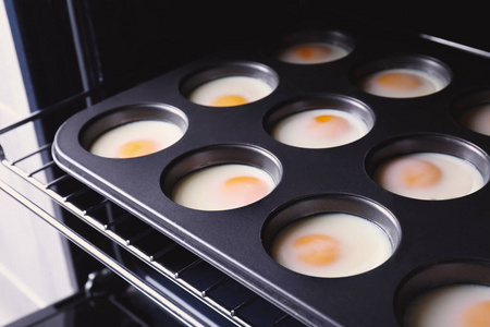 把鸡蛋放在烤箱的松饼罐